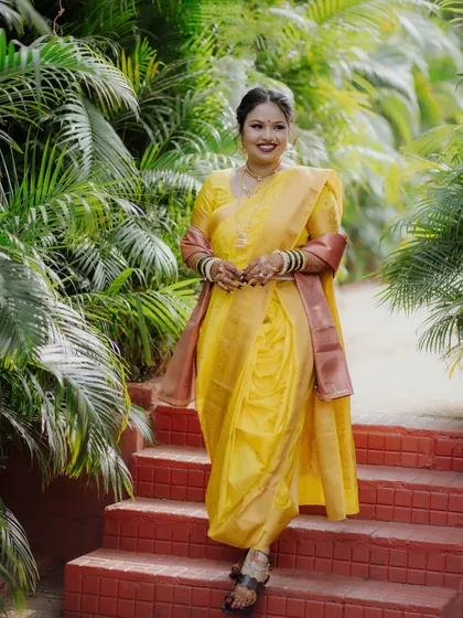 This bride is all smiles in her yellow Nauvari saree. The makeup is fresh and radiant, perfect for a daytime wedding ceremony.