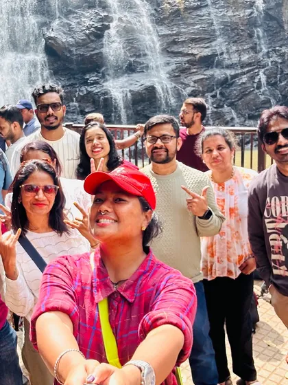 A happy group selfie in front of Abbey Falls in Coorg. Capturing memories with new friends is a key part of the Adventure Buddha experience.