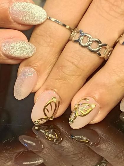 A chic combination of shimmery cat-eye nails and nude accent nails with 3D gold butterfly wing art.