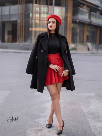 We used a modern building as the backdrop for this 'Paris style' shoot. The long black coat over the red skirt gives a sense of movement and sophistication, perfect for a fashion-forward portfolio.