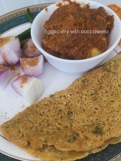 A creative and protein-packed meal of eggs curry served with an oats cheela and a side of raw onions.