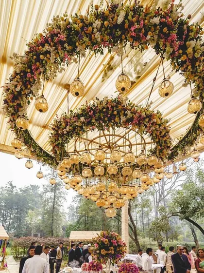 A magnificent floral chandelier created for an English day wedding. This double-ring of fresh flowers served as a stunning centerpiece for the outdoor tented reception.
