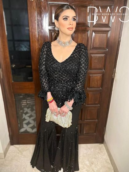 A full-length shot of the client, her sleek ponytail complementing the modern and chic vibe of her outfit.