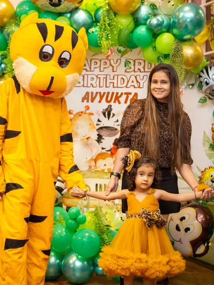 A friendly tiger mascot joins the birthday girl for a photo at her jungle-themed party. Mascot visits add an extra layer of magic to the celebration.