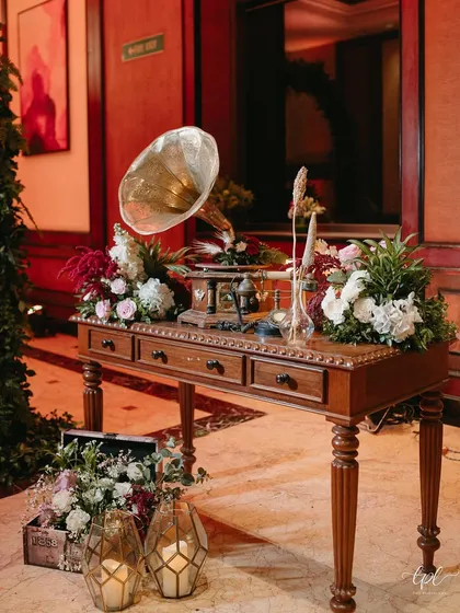 A vintage console table with a gramophone serves as a beautiful and thematic decor piece.