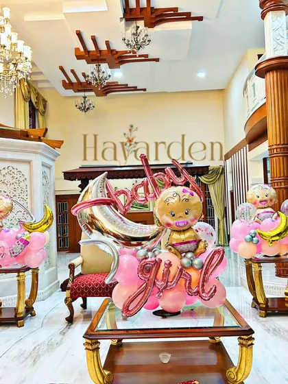 A grand 'Welcome Home Baby Girl' decoration in a luxurious living room. I used multiple balloon bouquets to fill the space and create a festive atmosphere.