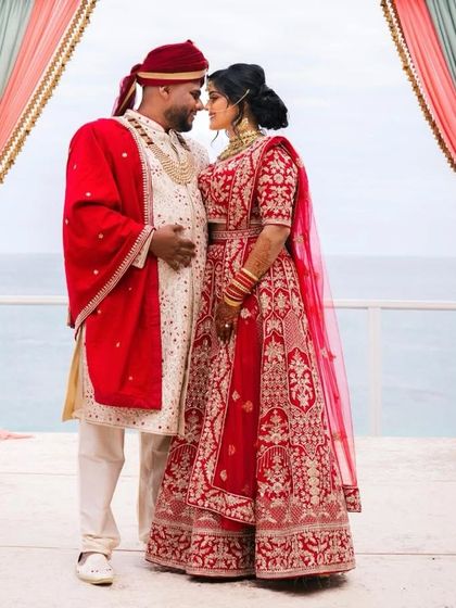 For this destination wedding, I designed a cream sherwani with all-over work, paired with a rich red velvet dupatta to create a powerful, coordinated look with the bride.