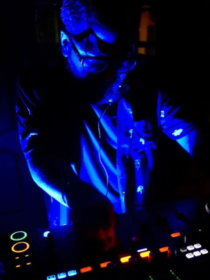 A close-up shot of me mixing under cool blue lights. This is my office, where I blend sounds and create energy for the dancefloor.