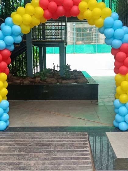 A simple and effective balloon arch in Pokemon colors of red, yellow, and blue for a party entrance.