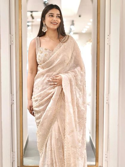 Make a stunning statement in this exquisite pastel saree, adorned with intricate embellishments.