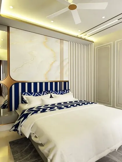 A bedroom design that plays with contrast. The deep blue upholstered headboard stands out against the marble and wood-paneled wall, creating a bold and luxurious statement.