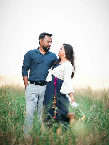 A candid portrait of the couple in a beautiful, sunlit field. Their expressions show a comfortable and happy connection.