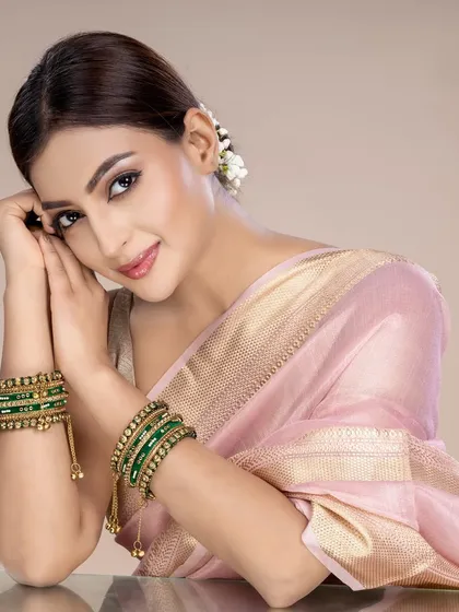 A close-up of a model wearing green bangles with delicate gold work. The focus on the hands and jewellery makes this an excellent shot for e-commerce product pages.