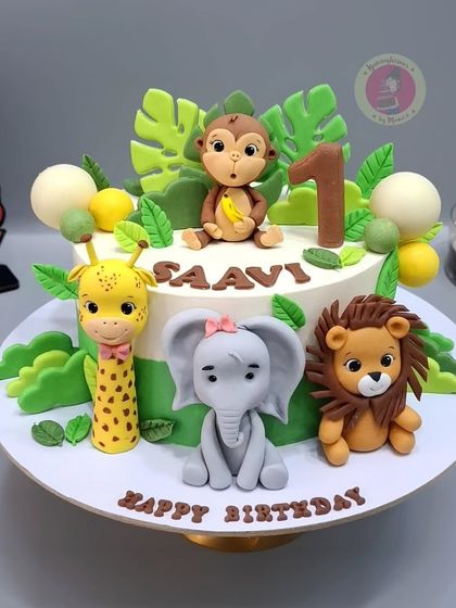 Our bestseller jungle-themed cake, featuring a monkey, giraffe, elephant, and lion. We make these almost every day!