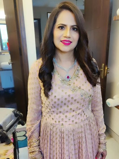 Here is Mansi's final party look. I focused on creating a soft glam effect with a bright pink lip, gentle waves in her hair, and a flawless base that looks natural and glowing.