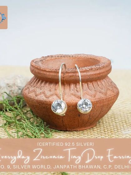 These tiny drop earrings feature a clear, sparkling zirconia stone, mimicking a dewdrop. They are incredibly versatile and lightweight.