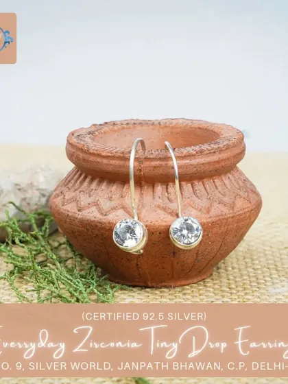 These tiny drop earrings feature a clear, sparkling zirconia stone, mimicking a dewdrop. They are incredibly versatile and lightweight.