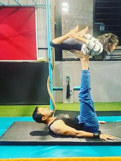This is a foundational Acroyoga pose called "Bird." I act as the base, supporting my student as she learns to balance and engage her core. It's a great starting point for beginners.