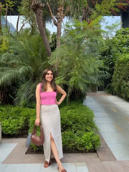 This outfit is all about relaxed summer elegance. The wicker chair and lush greenery provide the perfect backdrop.