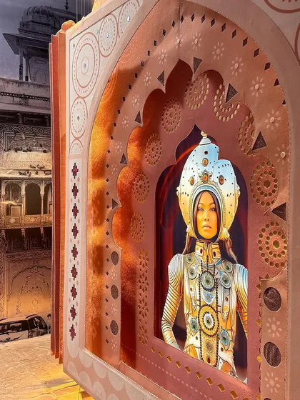 The 'Indofuturism' portrait, seen from an angle that highlights the layered, three-dimensional quality of the felt archway. The piece is a blend of digital printing, embroidery, and sculptural form.