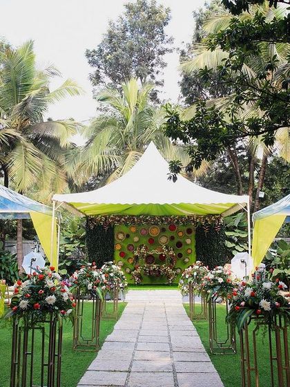A vibrant naming ceremony setup at Farmhouse Collective. The bright green and yellow decor against the lush backdrop creates a festive and joyful atmosphere.