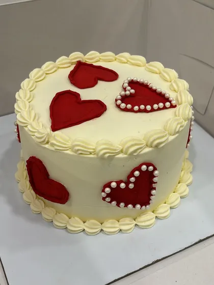 Simple and sweet. This cake is decorated with minimalist red hearts, some filled in and others outlined with pearls, showing that love can be expressed in the most charming ways.