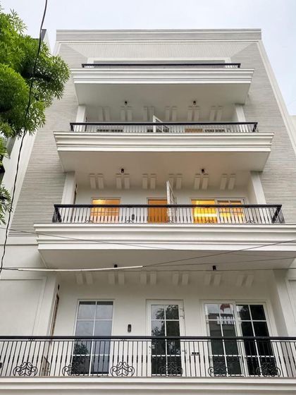 The classic white facade with contrasting black railings offers a timeless look. Each floor features a spacious balcony, creating a perfect blend of indoor and outdoor living.