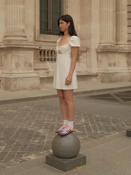 A model wearing custom sunset-themed Adidas Sambas at the Louvre in Paris.