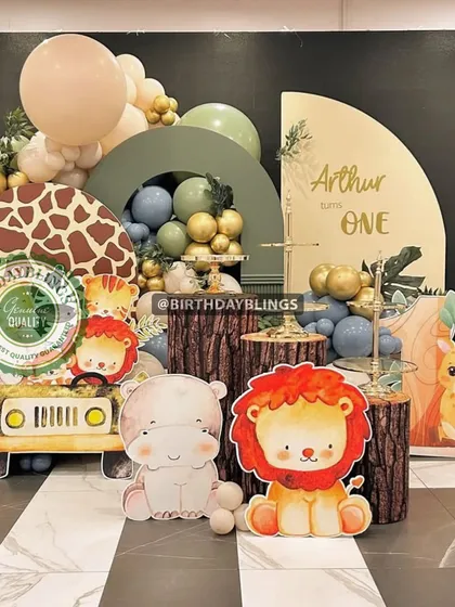 This adorable safari-themed first birthday uses cute, cartoon-style animal cutouts and log-themed plinths. The color scheme of sage green, grey, and gold creates a gentle and modern aesthetic.