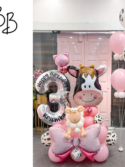 A cow-tastic celebration for Krishika's 3rd birthday! This adorable arrangement features a large cow head balloon, cow-print accents, and a big pink bow for a fun and girly take on a farm theme.