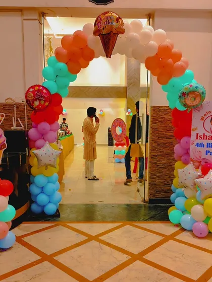 The entrance arch for the Candyland party, decorated with colorful balloons and large ice cream cone cutouts.