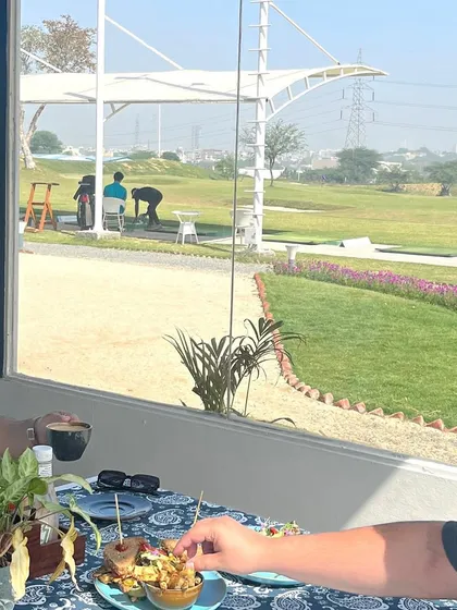 Enjoying a meal with a view. Our cafe's large windows look directly out onto the beautiful green driving range.