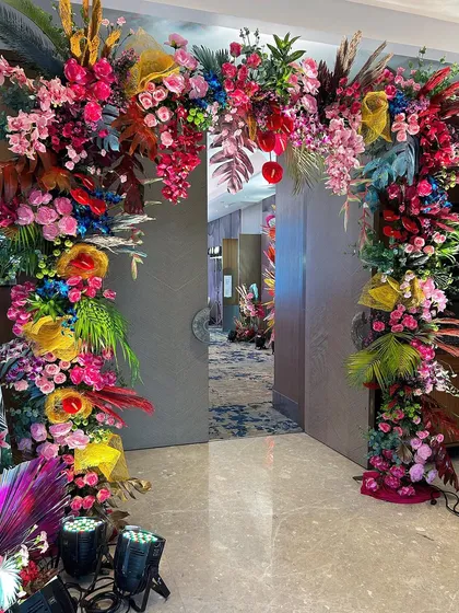 This banquet gate was designed for a carnival-themed event. The arch is overflowing with a riot of colorful flowers and tropical leaves, creating a vibrant and high-energy welcome for guests.