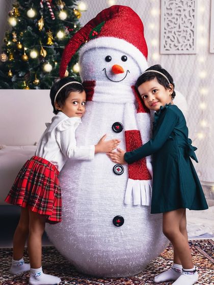 These two sweet girls giving our studio snowman a big hug. I love capturing the pure joy and imagination of children during our Christmas sessions.