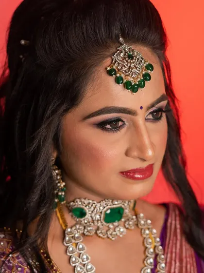 A dramatic and glamorous reception look for my sister Sushma. The bold, winged eyeliner and shimmery eyeshadow are paired with a statement emerald and diamond jewellery set.