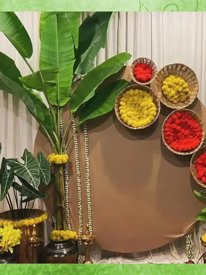 For a South Indian themed photobooth, I used a backdrop of banana leaves and baskets of red and yellow flowers. This design is a beautiful nod to tradition and creates a vibrant photo opportunity.