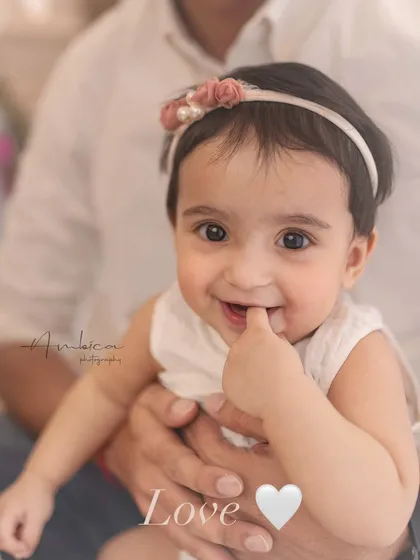 That little finger-in-the-mouth smile is just everything. A close-up shot that perfectly captures the adorable and innocent nature of a baby.
