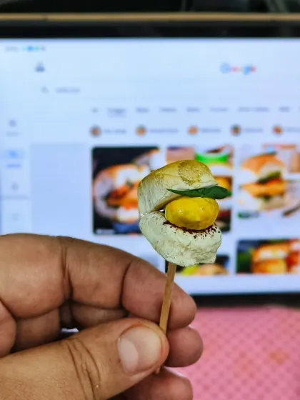 Crafting a miniature, edible vada pav. This tiny detail was part of a larger story cake, representing one of the person's favorite foods.