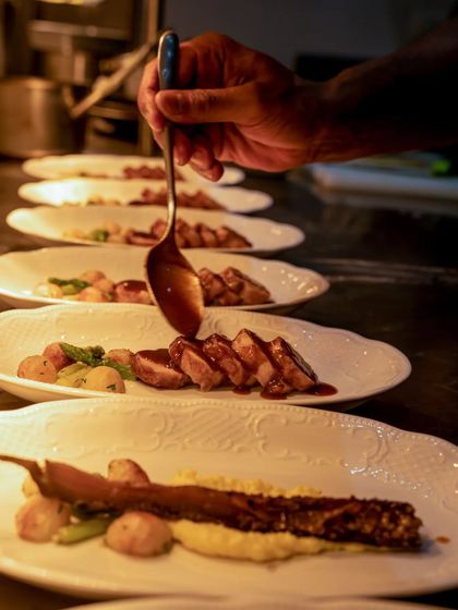 Another shot of a chef saucing a beautifully arranged plate.