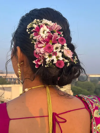 A beautiful floral hair arrangement with pink and white chrysanthemums, perfect for a daytime wedding or pre-wedding event.
