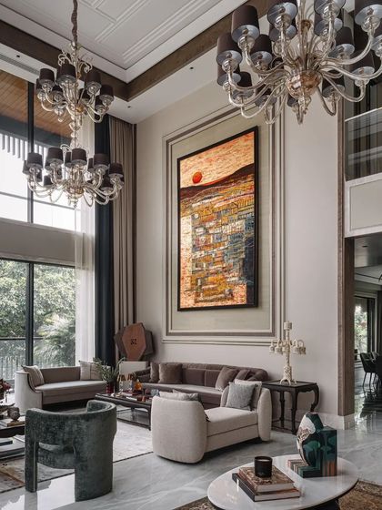 Grand chandeliers and large-scale art create a sense of drama and luxury in the formal living room.