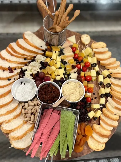 My lavish grazing boards are a feast for the eyes and the palate. This overhead view shows a generous spread of assorted cheeses, breads, crackers, nuts, fruits, and dips, perfect for social gatherings and cocktail hours.