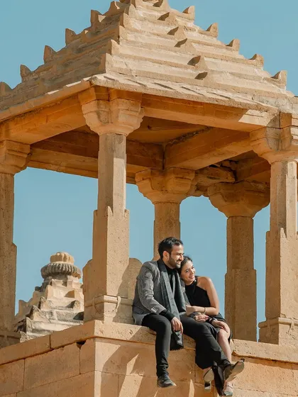 A quiet, shared moment perched atop an ancient cenotaph, overlooking the Jaisalmer landscape. This photo captures a sense of peace and togetherness, away from the world, just the two of you.