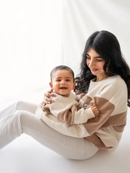 A sweet mother and son moment. The matching outfits and simple white background really let their happy expressions shine.