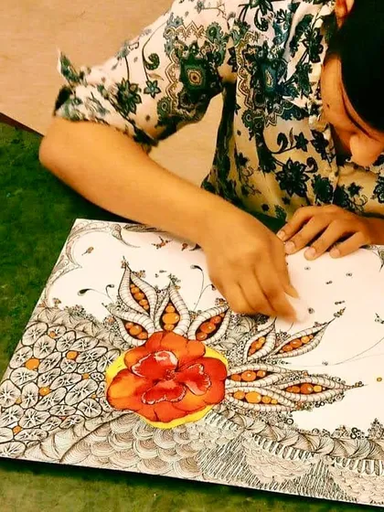 An adult student works on an intricate floral zentangle, a meditative art form that combines drawing with detailed patterns.