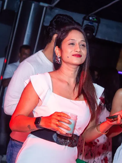 A guest with a drink in hand, enjoying the vibe.