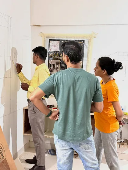 Here, I'm sketching the design for a TV unit directly on the wall for the clients to see. This hands-on approach ensures we are all on the same page.