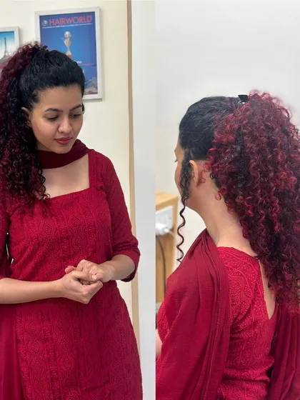 For this client, we embraced her beautiful natural curls with a fiery red balayage. The deep red tones are painted on to enhance the texture and volume of her hair, creating a bold yet elegant look, shown here styled in a high ponytail and also worn down.