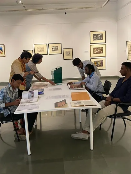 More visitors gathered around the library table, a hub of learning within the exhibition.