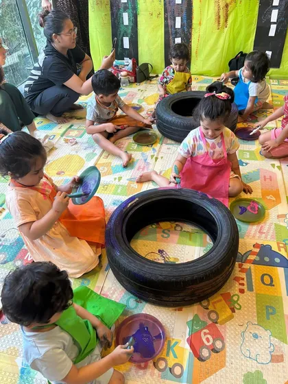 Here's a look at our Transport Week activity in full swing. The kids are using old tires as a canvas, learning about vehicles while engaging in a large-scale, collaborative art project.